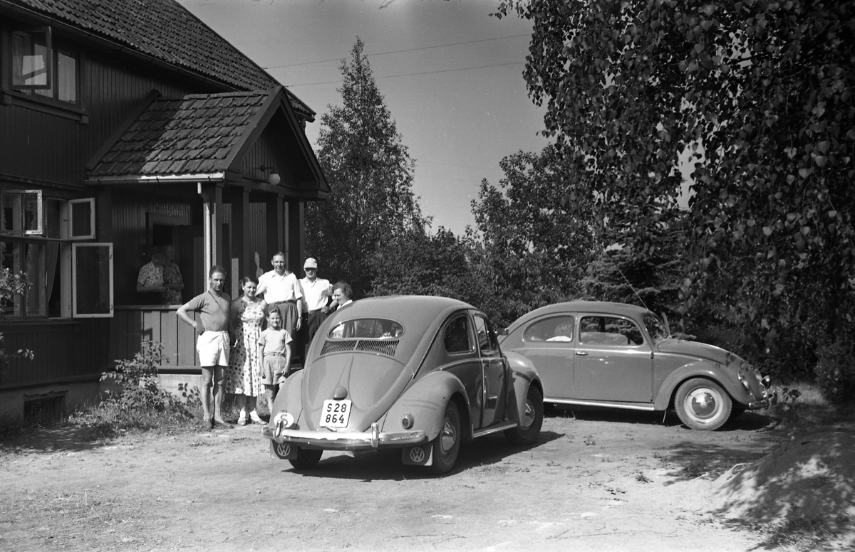 Campinggjester hos Sigurd Røisli sommeren 1955. Det var noen svensker på tur som spurte om de kunne telte på plenen foran huset. To bilder. På det første sitter "vertinna" Karine Røisli oppe på verandaen. De øvrige er ukjente.