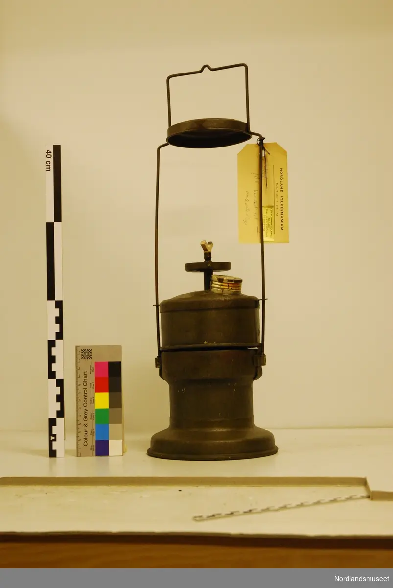 Metal lamp with handle to carry, cylinder form, reservoir in the bottom part