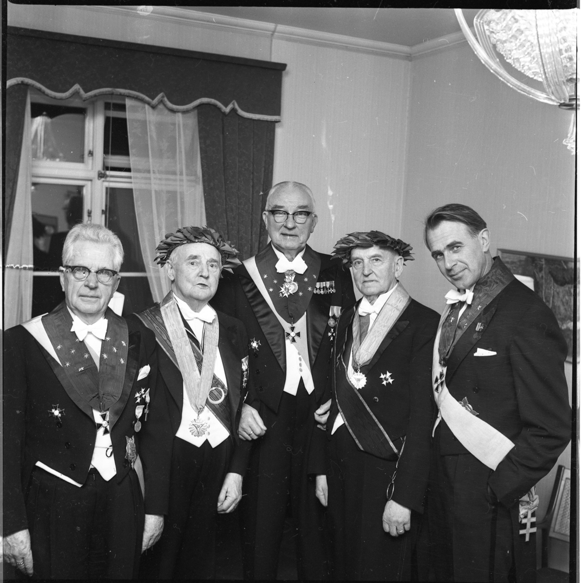 Sällskapet Par Bricole har sammankomst. Fyra okända män samt C-W Lothigius till höger, i högtidsdräkt med ordnar och band på bröstet.