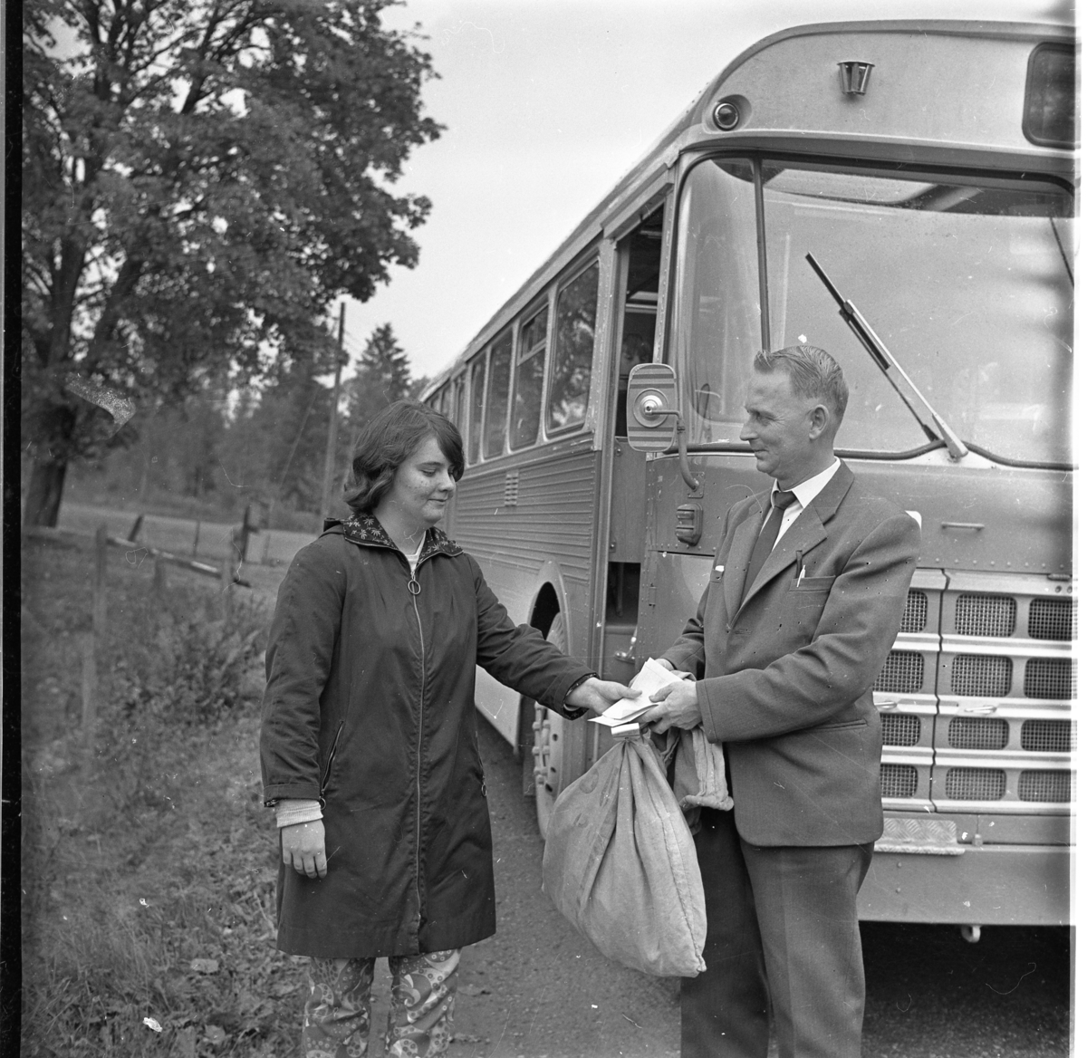 Ulla Pettersson, 'Post-fröken', i Haurida lämnar den sista postsäcken till busschauffören Folke Öst.