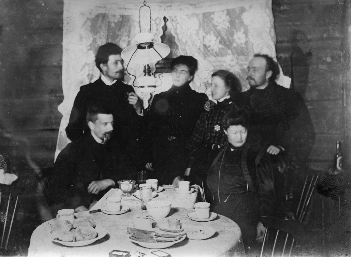 Reisende hos Siljesæter sitter rundt et oppdekt bord 28.12.1907.