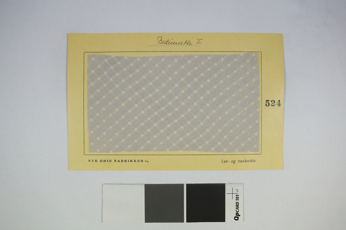 Prøvekort bestående av tekstilprøve limet til et papirkort. Rutete mønster.
