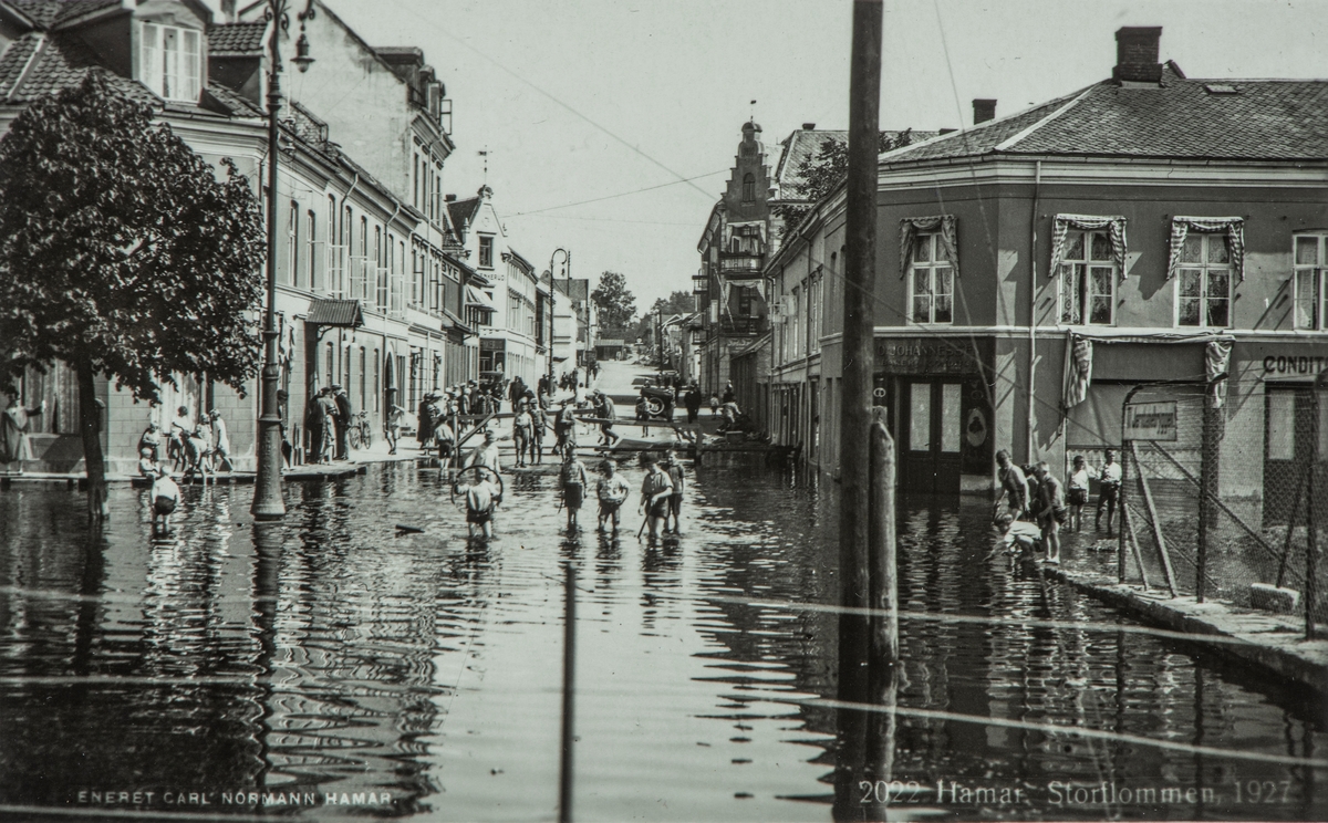 Postkort, Hamar, Strandgata, flommen i 1927. Mjøsflommen 1927, Barn leker i flomvannet i Strandgata, Enggata utenfor Victoria hotel, baker Johannessen,