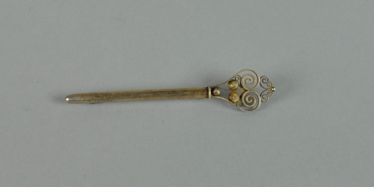 Stavformet brosje av sølv, med filigran nøkkelhodedekor.