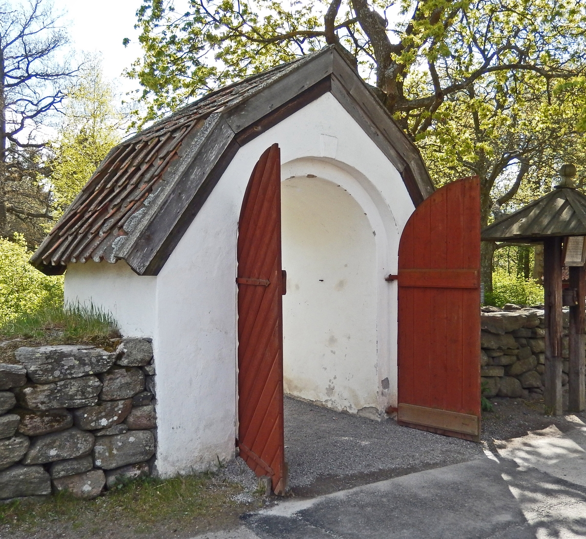 Den västra stigluckan, kyrkogårdsporten, vid Seglora kyrka på Skansen är murad, putsad och vitkalkad. Taket är brutet och klätt med enkupigt tegel. Portdörrarna är av trä, rödmålade, med stående panel på insidan samt fiskbenspanel på utsidan. Västra stigluckan på Skansen är uppförd som en kopia av den västra stigluckan vid Seglora kyrka i Västergötland.