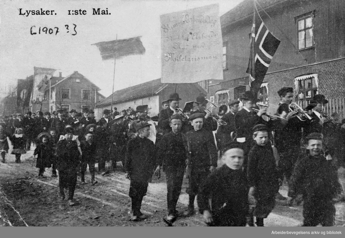 1. mai-demonstrasjon på Lysaker i Bærum, 1907. Paroler: 8 timers Arbeidsdag; Ræt til Arbeide Ned med Miletarismen.