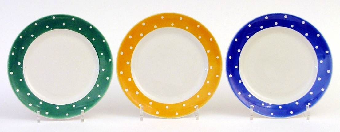Tre stycken assietter i serien Amanita från Gefle porslin.

En gul, en blå, en grön i brämmen, med vita prickar.