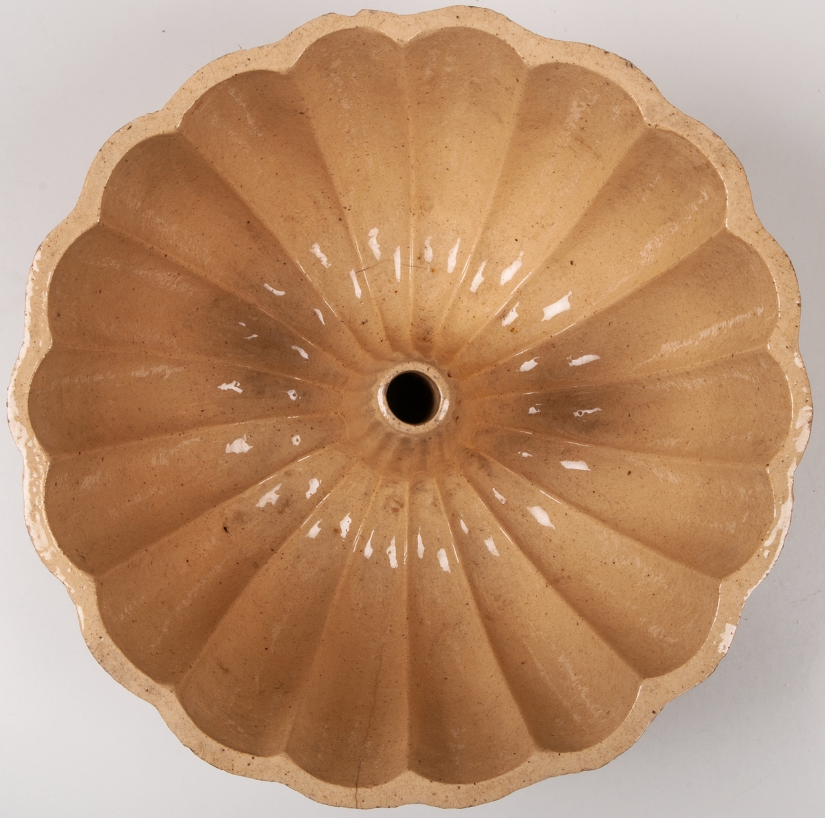 Gul puddingform form av flintgods, rund räfflad med pip.
Märkt:
2 L Höganäs.
KH