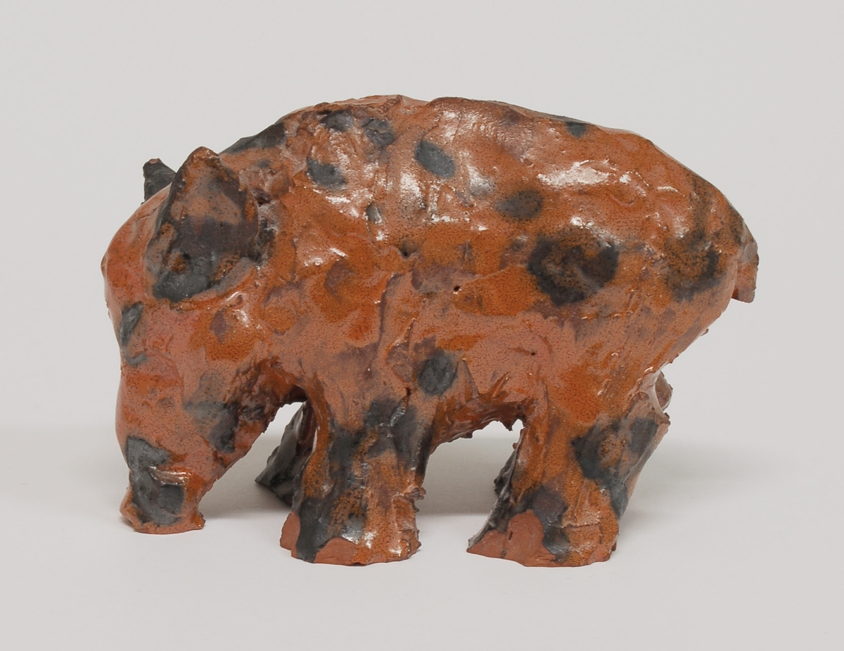 Figurin, vildsvin, orangebrun glasyr, lergods, formgiven av Märta Willborg, 1930-talet.
