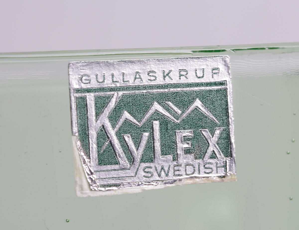 Rektangulär, stor kanna/kylskåpsglas. Närmast en kub med handtag på ena kortsidan och snip på den andra. Rektangulär etikett i grönt och silver med text "Gullaskruf Kylex Swedish".

Inskrivet i huvudkatalogen 1980.