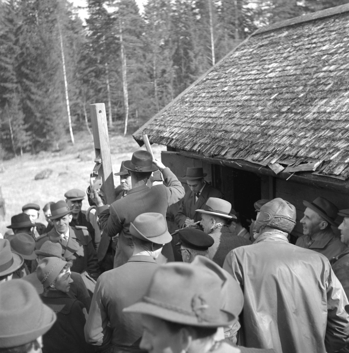 Förre skogsvaktaren Johan Elof Anderssons bohag går under klubban i april månad 1961. I fotoögonblicket utropas hans rubank. Platsen är Bergstugan i Gammalkil socken.