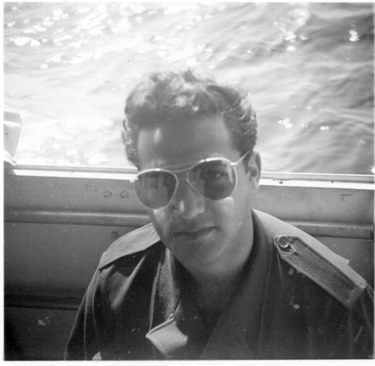 Porträtt av man med solglasögon som befinner sig på en båt.