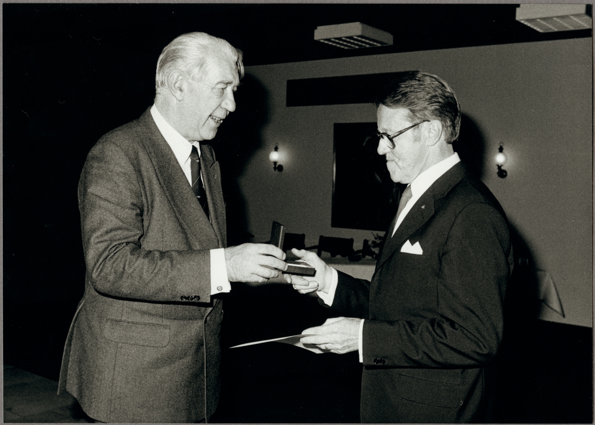 Ragne Johanson delar ut silvermadalj till Sven Larsson för sina många förtjänstfulla år inom driftvärnet, på Trafikaktiebolaget Grängesberg - Oxelösunds Järnvägar, TGOJ: s personalafton på Hotell Smeden i Eskilstuna den 24 oktober 1986.