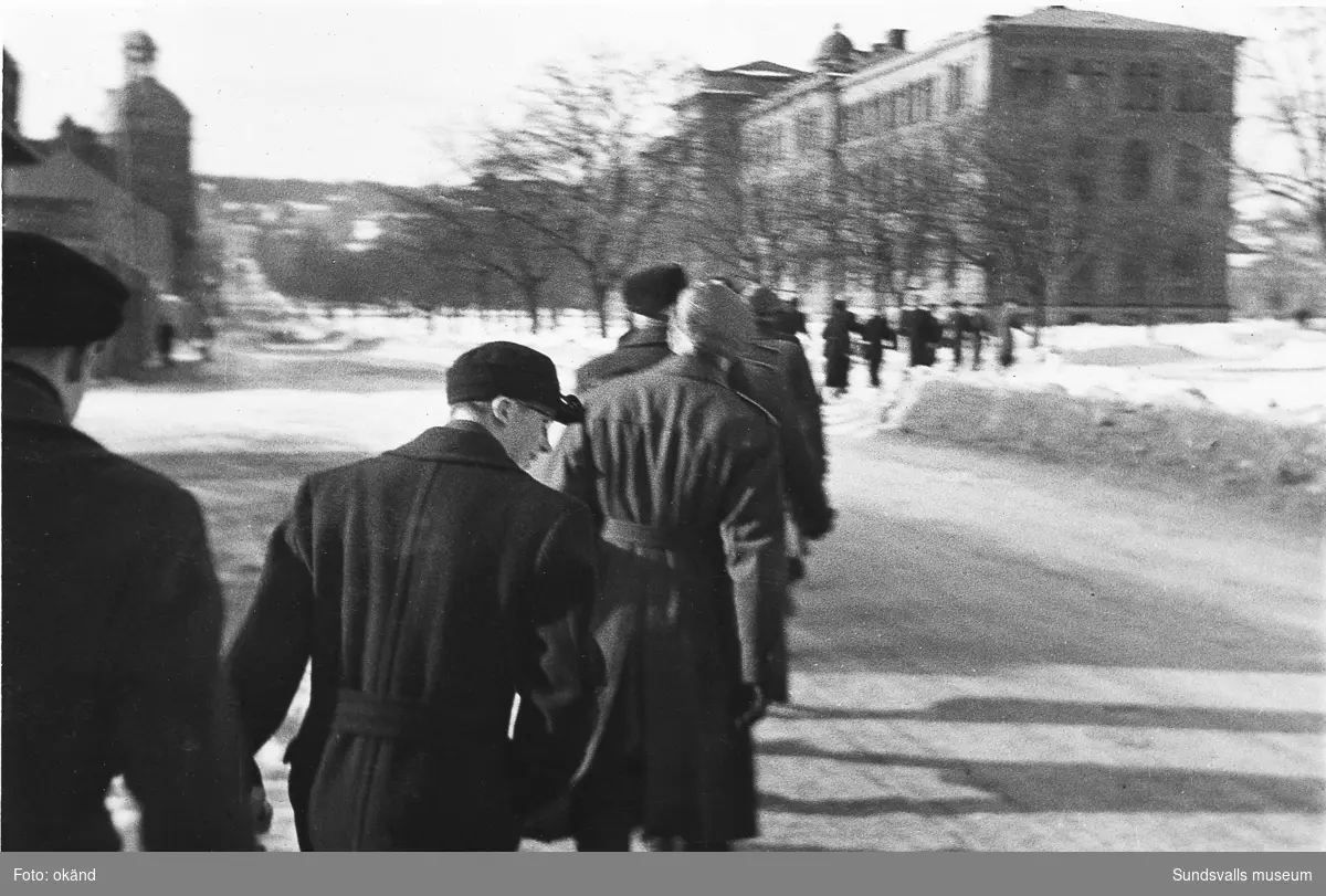 "Studentexamen 1937 vid Sundsvalls högre läroverk började med svensk skrivning. Innan vi gick till skolan samlades vi vid Bewe's hörna (Storgatan-Torggatan). Där släppte var och en av oss en ettöring från födelseåret ner i dagvattenbrunnen. Därefter gick vi till skolan med en fot i rännstenen och den andra på trottoaren så lång det gick." Bild 2 Fr v Lennart Uhlin, Ture Engblom och Martin Löfgren. Bild 6 Betygen studeras. Fr v Liljekvist, Curt Stål, L M Thuresson samt okänd. Bild 8 Numrerade personer. 1. okänd 2. L. H. Thuresson 3. okänd 4. Thure Engblom 5. okänd 6. Martin Löfgren 7. Lundgren (?) 8. Curt Stål 9. G-A Wahlsten 10. Ingemar Flodén 11. Anna-Lisa ? 12. Nilsson (lärare) 13. Maidi Budde 14. Lennart Uhlin 15. Harald Schibbye. 
Bilder ur fotoalbum som tillhört G A Wahlsten.