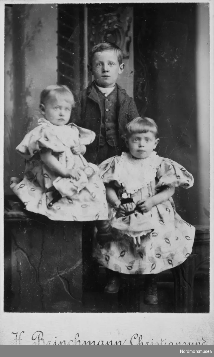 Gruppefoto av tre barn. Trolig fra Kristiansund, siden det er der de er fotografert. Det er H. Brinchmann som er fotograf. Fra Nordmøre museums fotosamlinger.