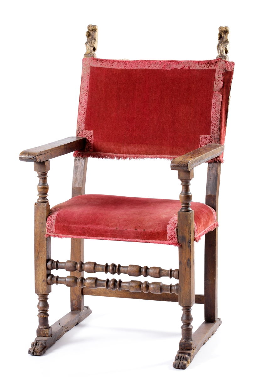 Karmstol av renässansmodell. 
Trästomme med svarvade detaljer. Sits och rygg klädda med vinröd sammet, kantad med brokadband i samma färg, med bladdekor.