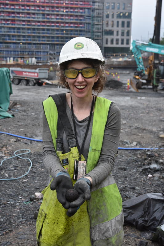 Bildet viser arkeolog Sarah Fawsitt som holder en kanonkule funnet i utgravingsprosjektet B8a