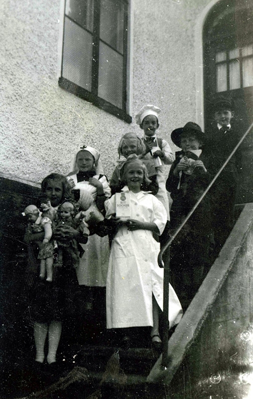 Utklädda barn står samlade i trappan till köket och lägenheten i Kållereds Missionskyrka cirka 1955. Teaterspel, antingen söndagsskolan eller scouterna.