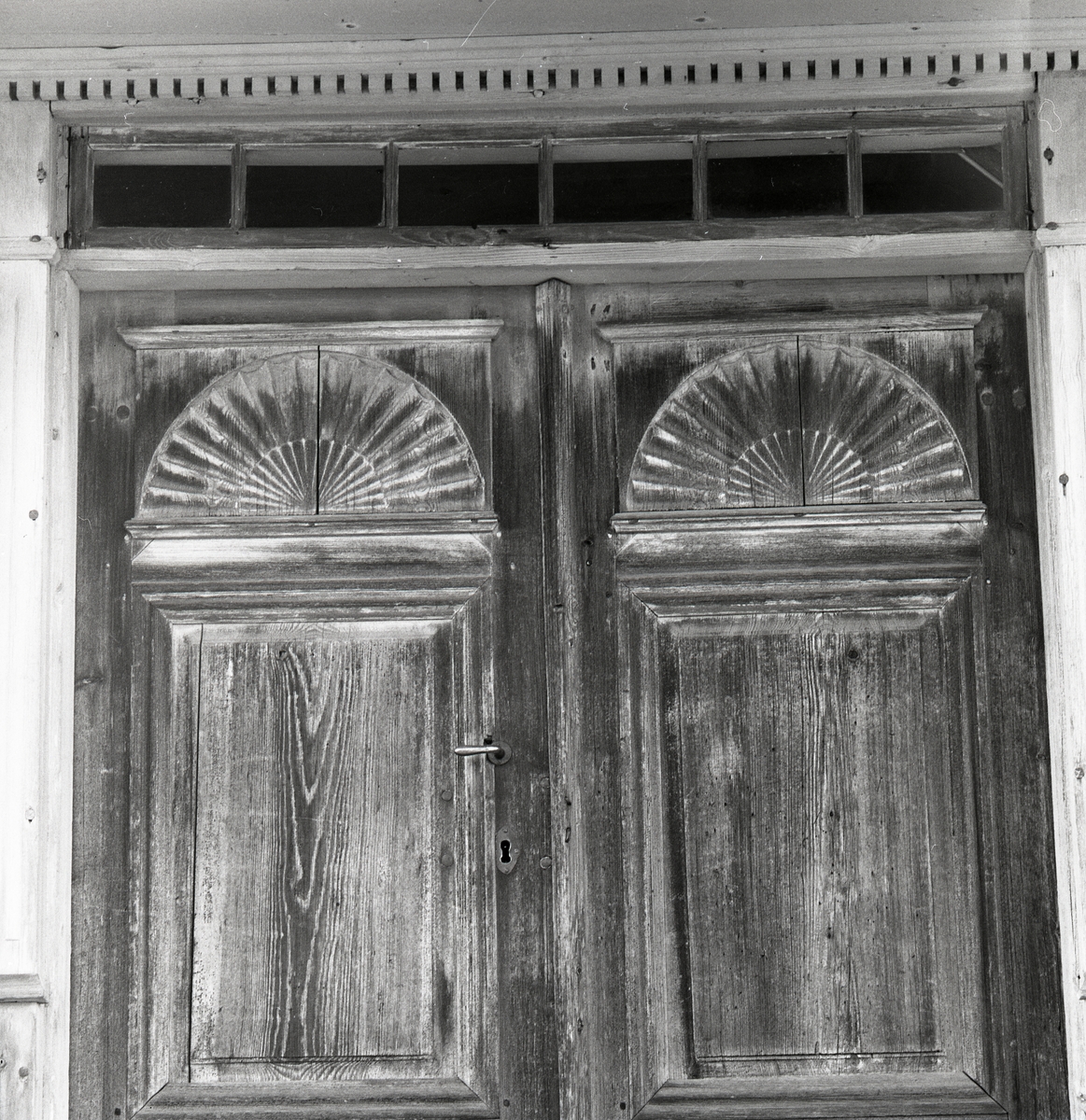 Vackra dörrar med handtag och nyckelhål, små fönster ovanför. Dörrarna i Norrgården 29 oktober 1990.