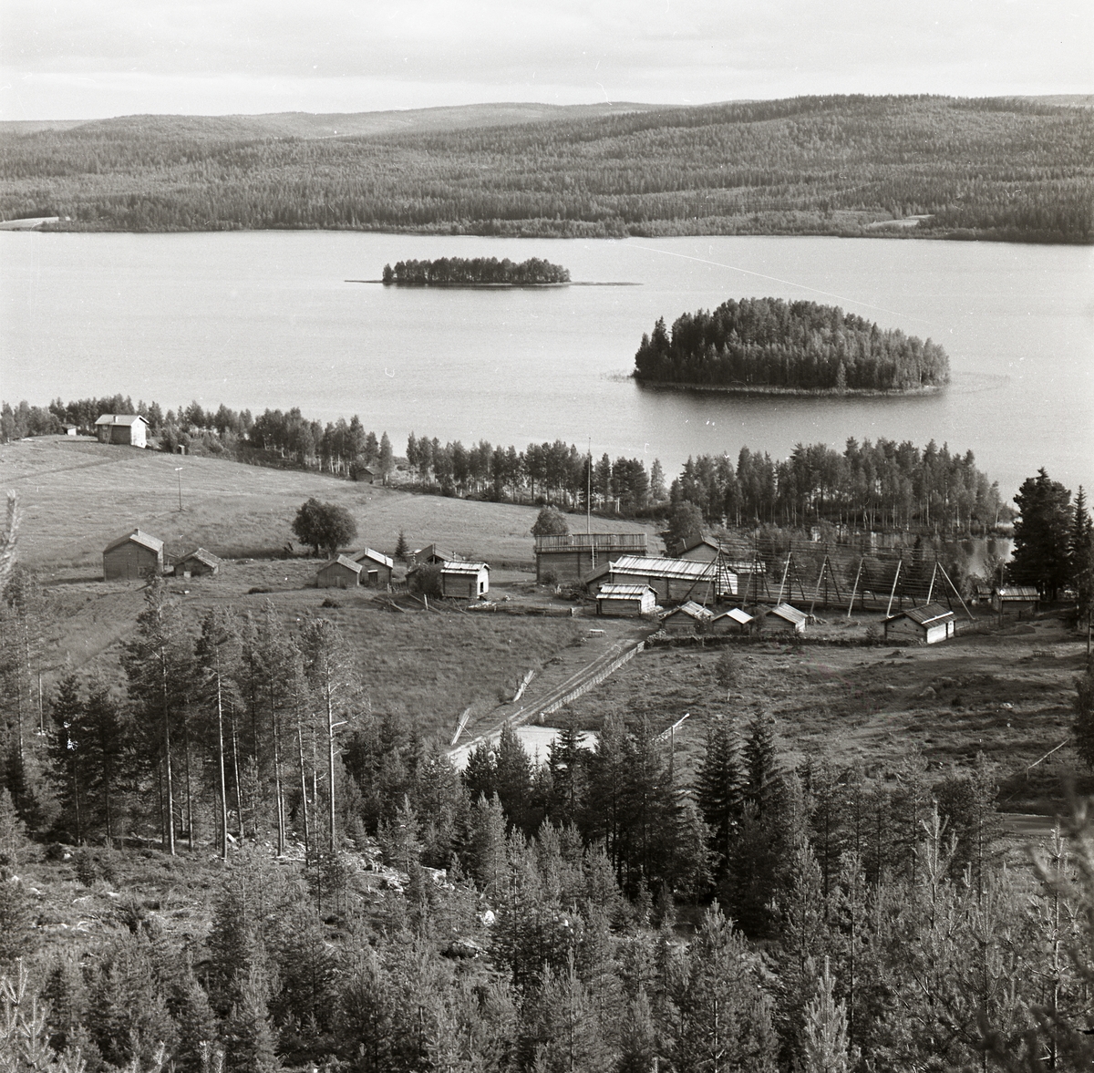 Utsikt över byggnader, sjö och berg i Myckelgensjö, Ångermanland, 1974.