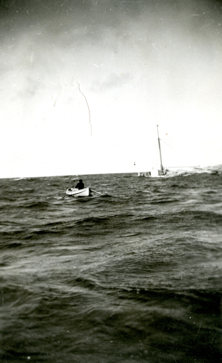 Mann i livbåt og synkende skip. Fra torpederingen av D/S 'Takstaas' i september 1939, fotografert fra torpedobåt KNM 'Storm'