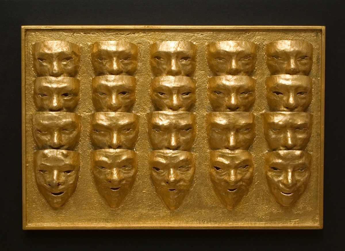"Stapelvara III" av Albert Johansson.
En förgylld platta med upphöjd ramkant 52 x 77, varpå monterats fem lodräta rader med i "äkta guld" förgyllda masker, fyra i varje stapel. Guldplattan är fäst på en svart bakgrundsplatta, 66 x 91.