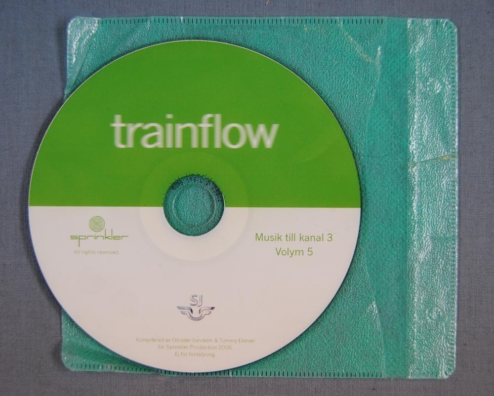 (Jvm 21512:1)
CD-skiva, där halva skivan är grön och halva är vit. På den gröna halvan står det med vit text "trainflow" och på den vita sidan är det en grön logga för sprinkler production och en silver SJ logga, samt grön text "Musik till kanal 3 Volym 5".

(Jvm 21512:2) Längd: 130 mm Bredd: 140 mm
Ljusgrönt mjuk plastfodral till CD-skivan så att den inte blir repad. På ena sidan är det märken för hål så att man kan sätta in fodralet med CD-skivan i en pärm.