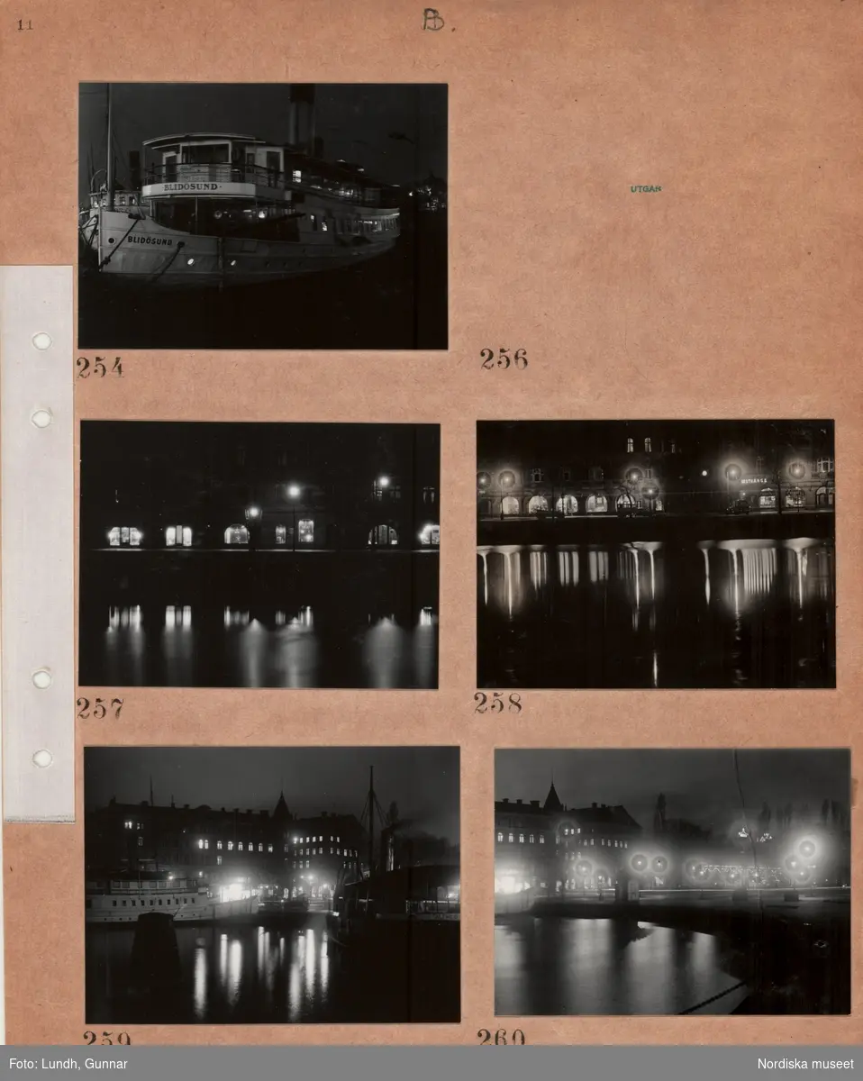 Motiv: Nybroviken (div) 252 - 262 ;
Nattbild med en ankrad båt "Blidösund", nattbild med vatten och exteriör av byggnad med skyltfönster, nattbild med vatten och stadsvy.