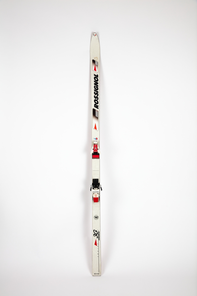 Et par Rossignol slalomski med Salomon bindinger. Skiene ligger i en blå skipose merket Salomon.