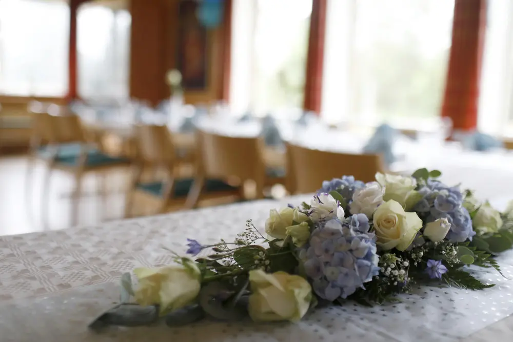 Storsalen pyntet med blomster til selskap