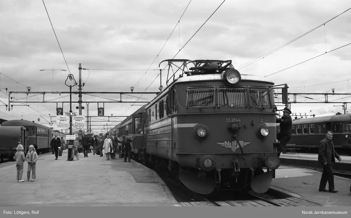 Elektrisk lokomotiv El 13 2144 med ekspresstoget fra Oslo Ø til Trondheim på Hamar stasjon. Til høyre materiell til tog 375 til Røros.