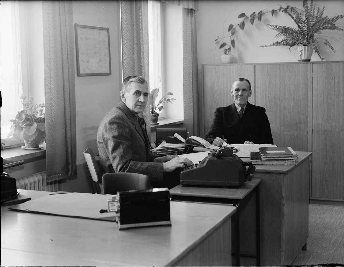 Två män arbetar vid ett skrivbord, Uppland
