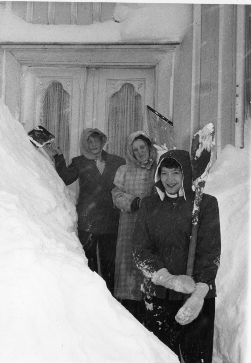 Vinter i Kragerø gate. Marie Rasmussen, Nelly og Anne Marie (Lilleba) Schaaning måker snø. 1970?