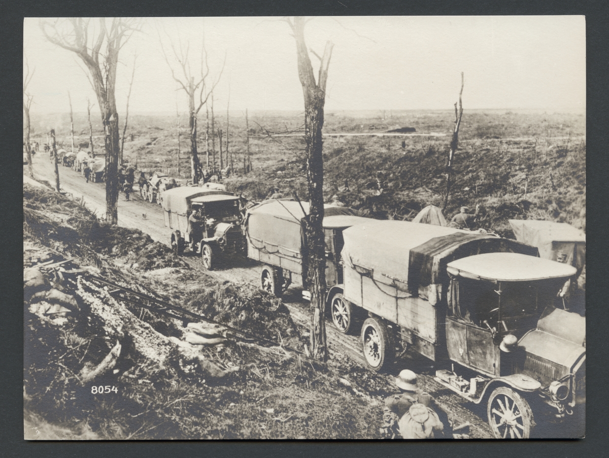 Bilden visar en kolonn lastbilar på en landsväg i en förstört landskap. I bakgrunden syns en kolonn hästfordon som rör sig i motsatt riktning.

Originaltext: "Tyska kolonner på frammarschvägen till Nesle."