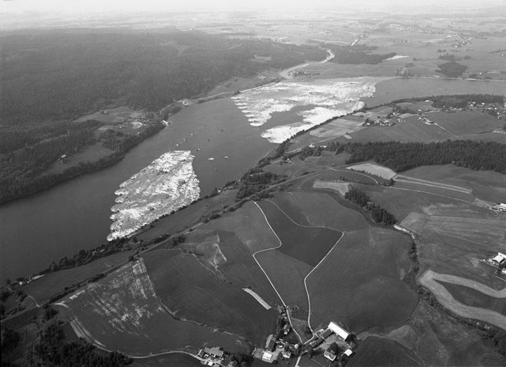 Flyfoto over parti av elv med mange tømmerstokker holdt på plass av lenser.