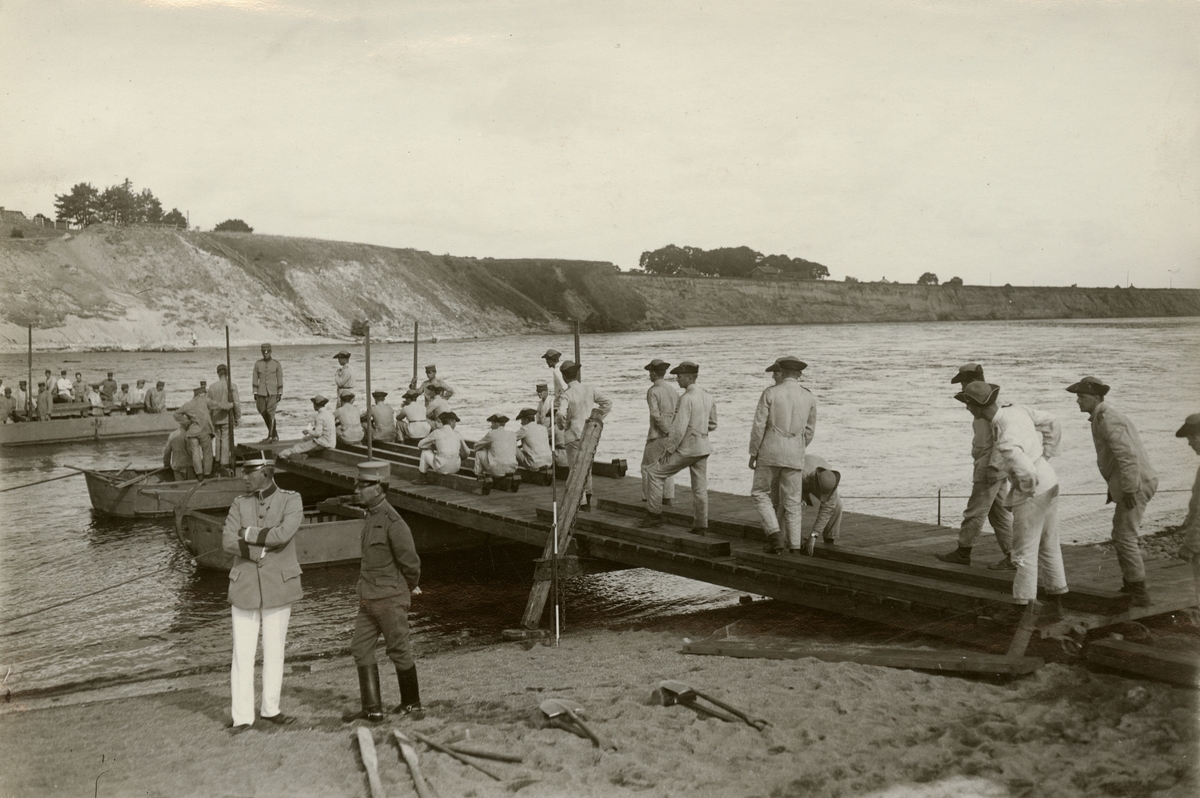 Elever från Krigsskolan Karlberg bygger pontonbro över vattendrag.