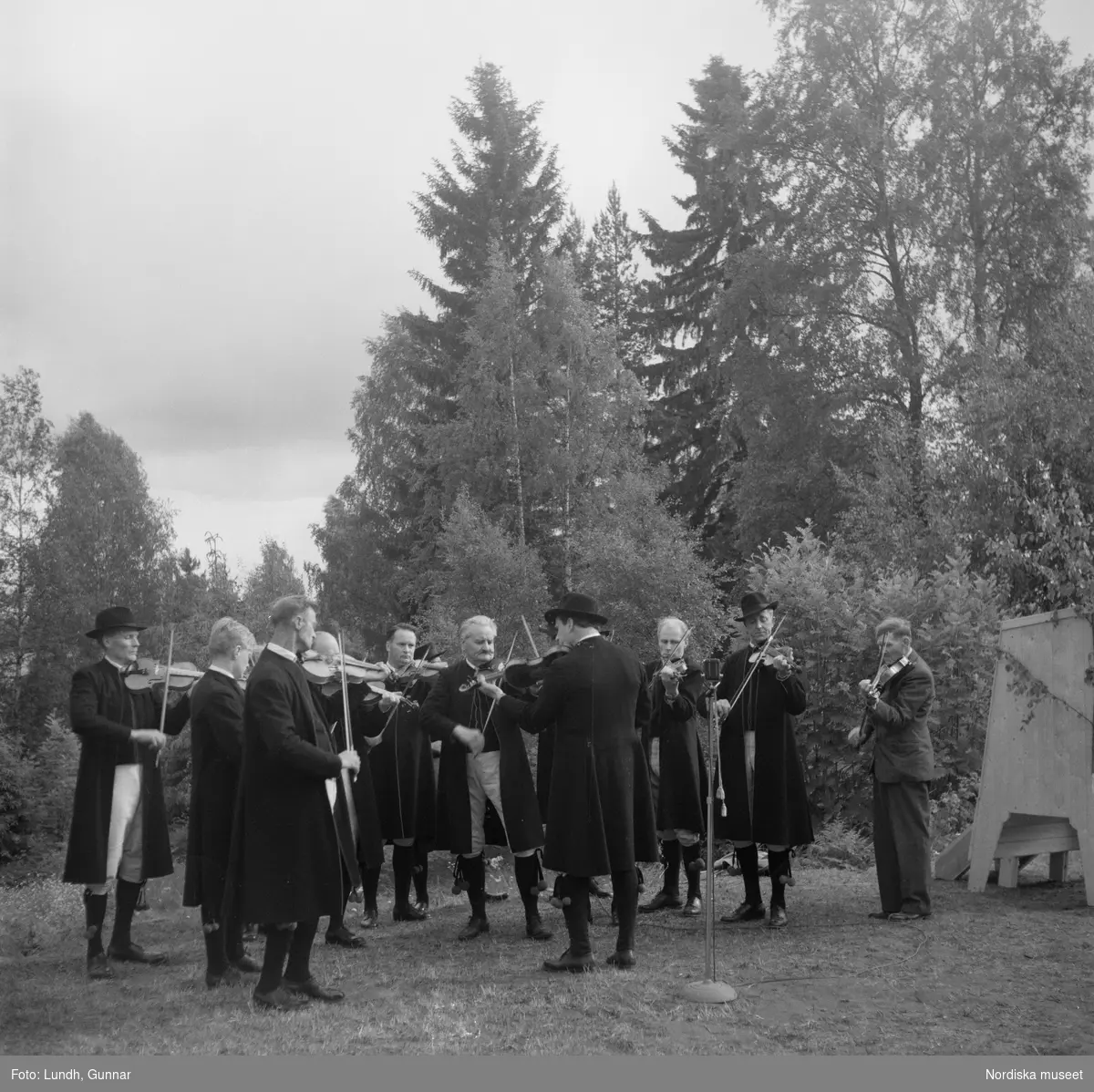 Motiv: (ingen anteckning) ;
Porträtt av en man - ett barn och en kvinna i folkdräkt, två kvinnor i studentmössor, män klädda i folkdräkt spelar fiol.