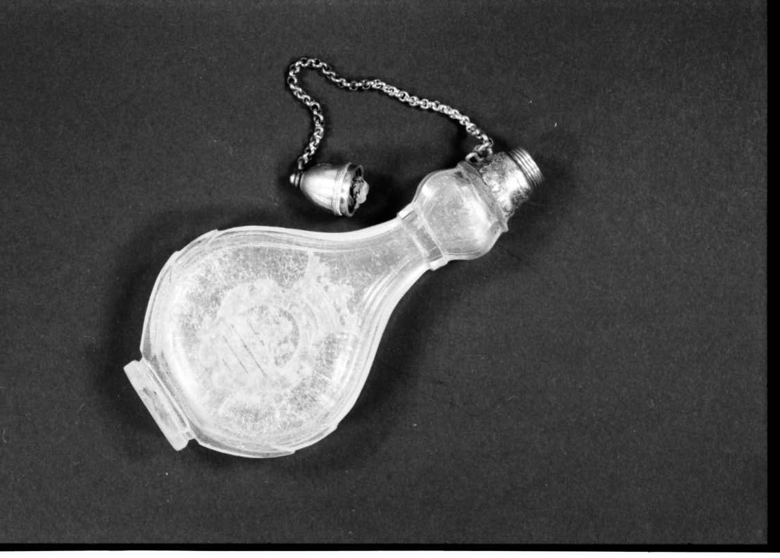 Fotografi av liten parfymflaska av glas.