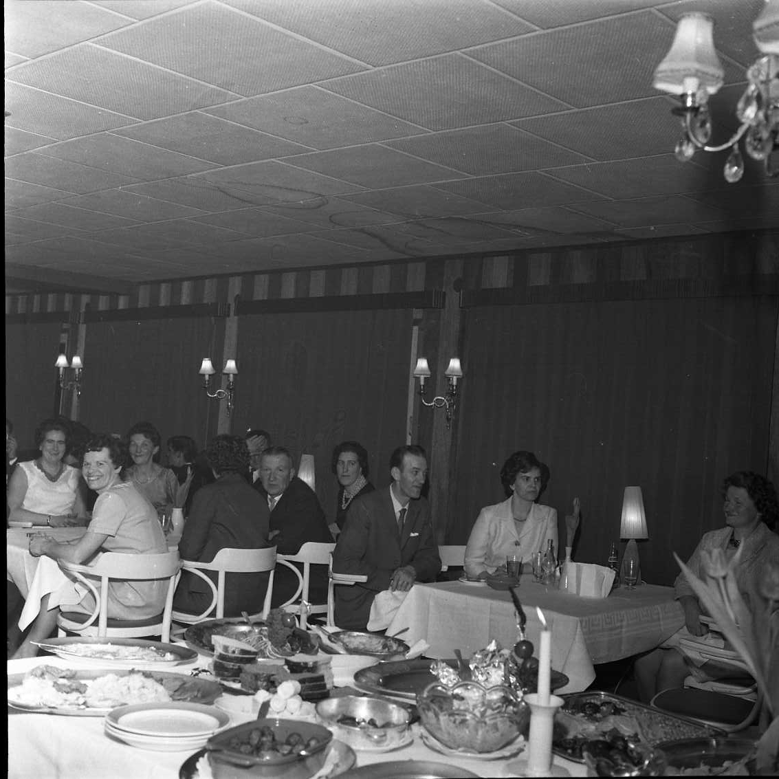 Årsmöte med prisutdelning i Gränna AIS. Män och kvinnor sittande vid dukade bord. I förgrunden ett bord mat mat.