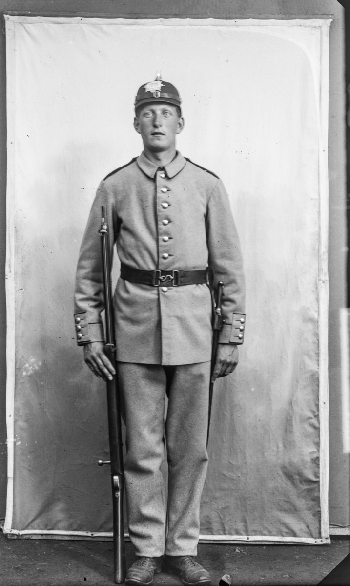 Soldat i uniform og hjelm modell 1888 for menige i hæren. Etter MPLs regnskapsbok er dette Karl Johan Iversen.