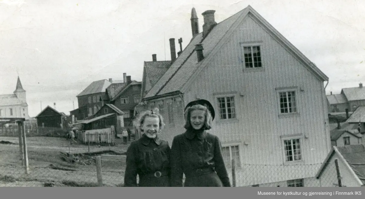 Honningsvåg. Inger Johanne Petterson og Aud Nordang foran sykestua. Til venstre Honningsvåg kirke. Sommeren 1941.