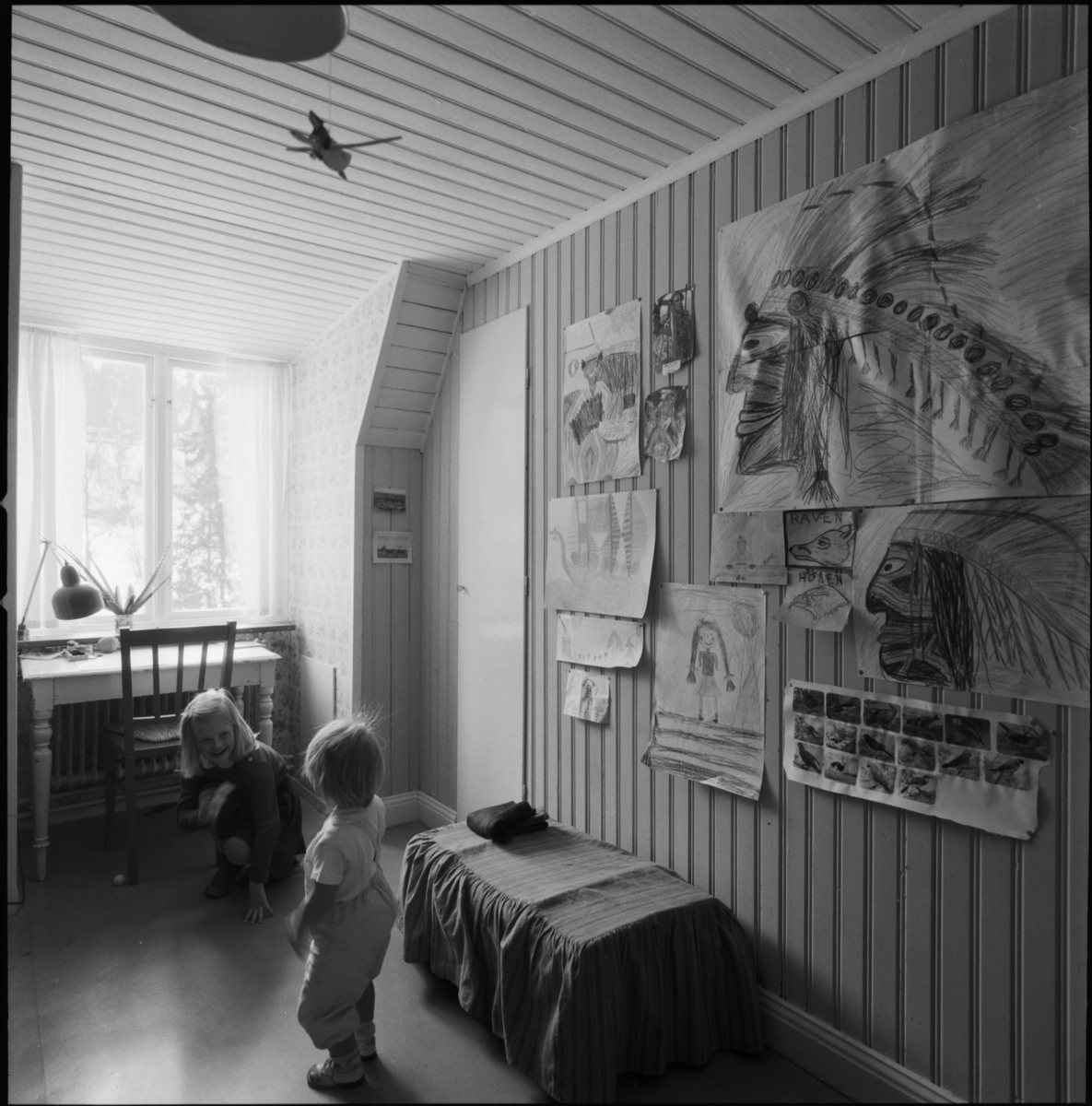 villa Ahlgren
Interiör av barnkammare med två små barn, på väggen barnteckningar.