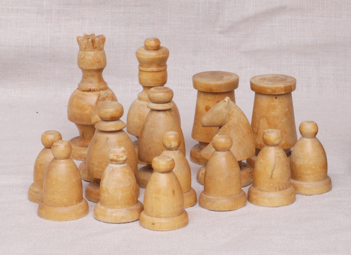 Hjemmelaget sjakkspill. Brettet er malt i hvitt og brunt. Brikkene er sortmalte og trehvite. Spillet er komplett.