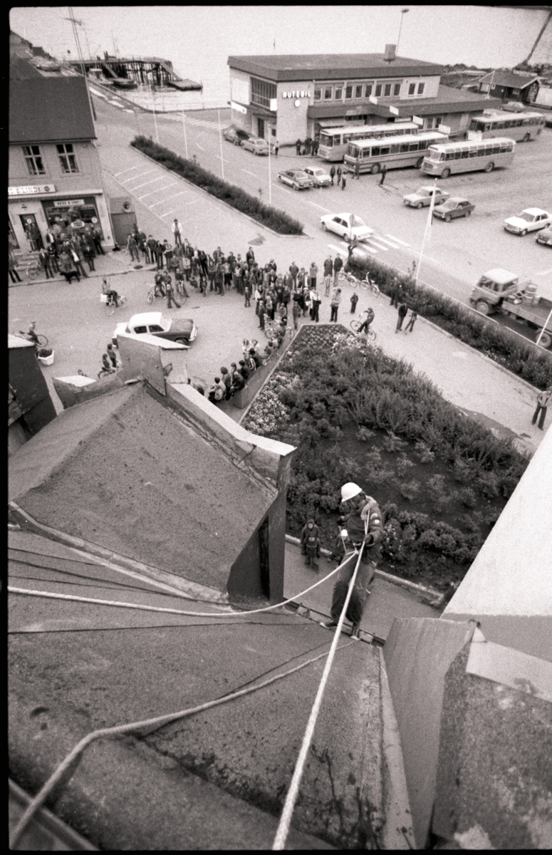 Harstad Røde Kors hjelpekorps øver på redning fra tak. Rutebilstasjonen i bakgrunnen.
