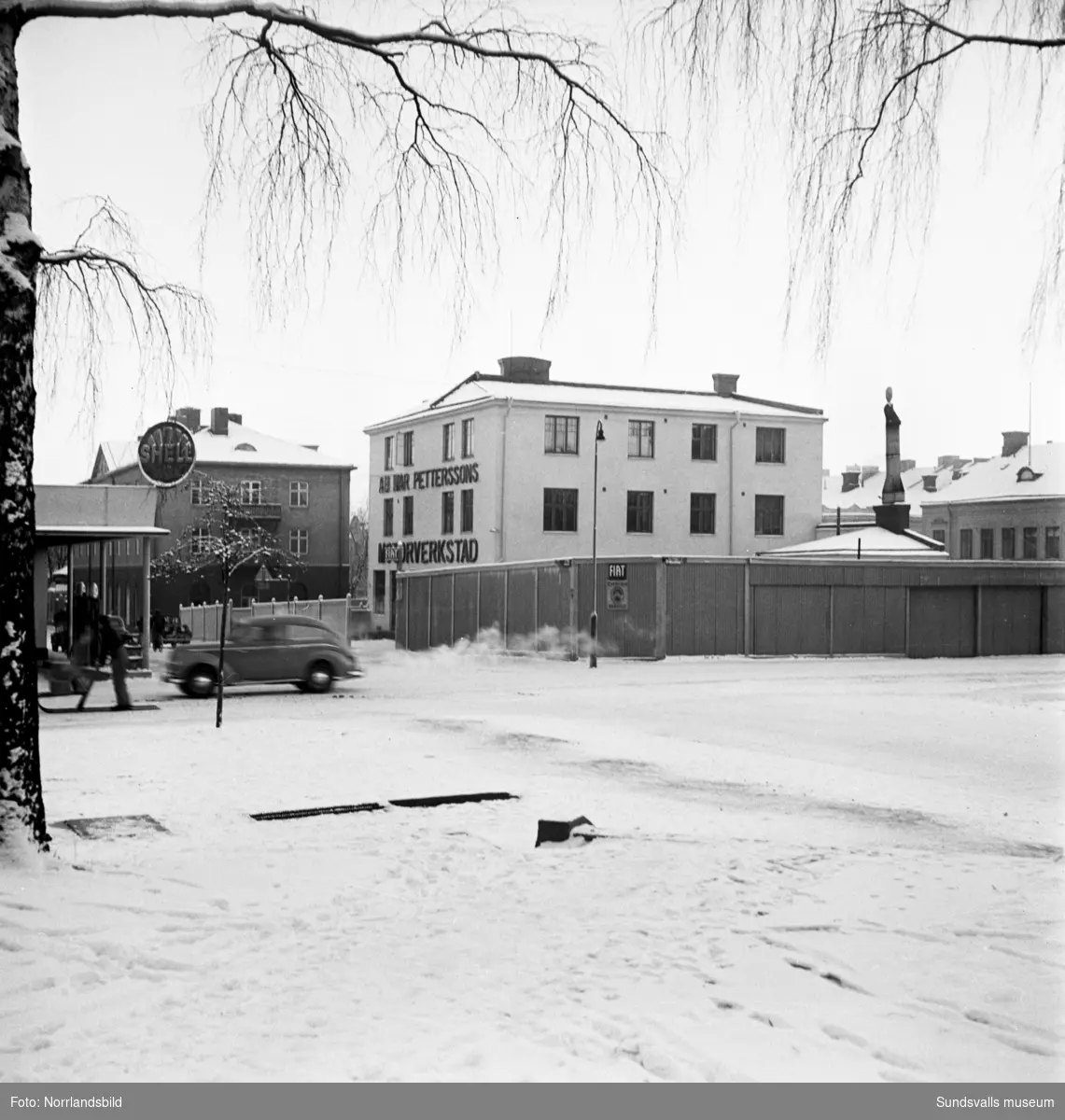 Kvarteret Fliten med Ivar Petterssons motorverkstad, fotograferat från hörnet av Skolhusallén och Kyrkogatan.