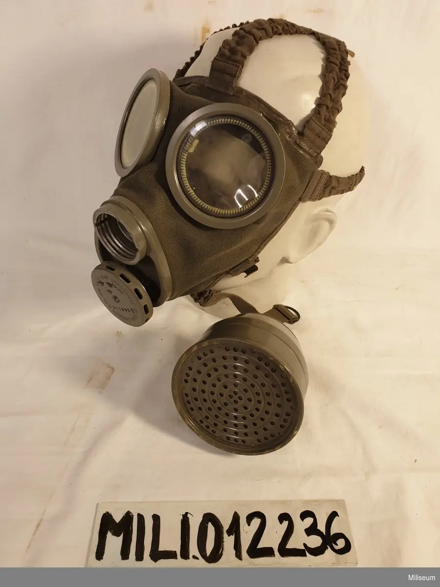 Civilförsvarsgasmask med behållare, filter, beskrivning och extra imskivor.