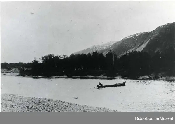 Elvebåt på Lakselva. Mann staker elvebåt fra østsiden av Lakselva til vestsiden ved Smørstad.
Johkafanas Leavnnjas. Dievdoolmmoš čuoibmu Leavdnjajogas Smørstad buohta nuorttabealde oarjjás.