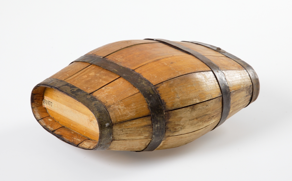 En oval, mindre vinkagge av trä och järn, på stativ av trä.
