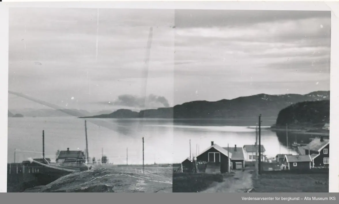  Fra Talvik, Alta. Bildet viser utsikt innover mot Alta. Hus og naust i forgrunnen. I bakgrunnen er det holmer til venstre, og ei bukt og fjell til høyre.  
