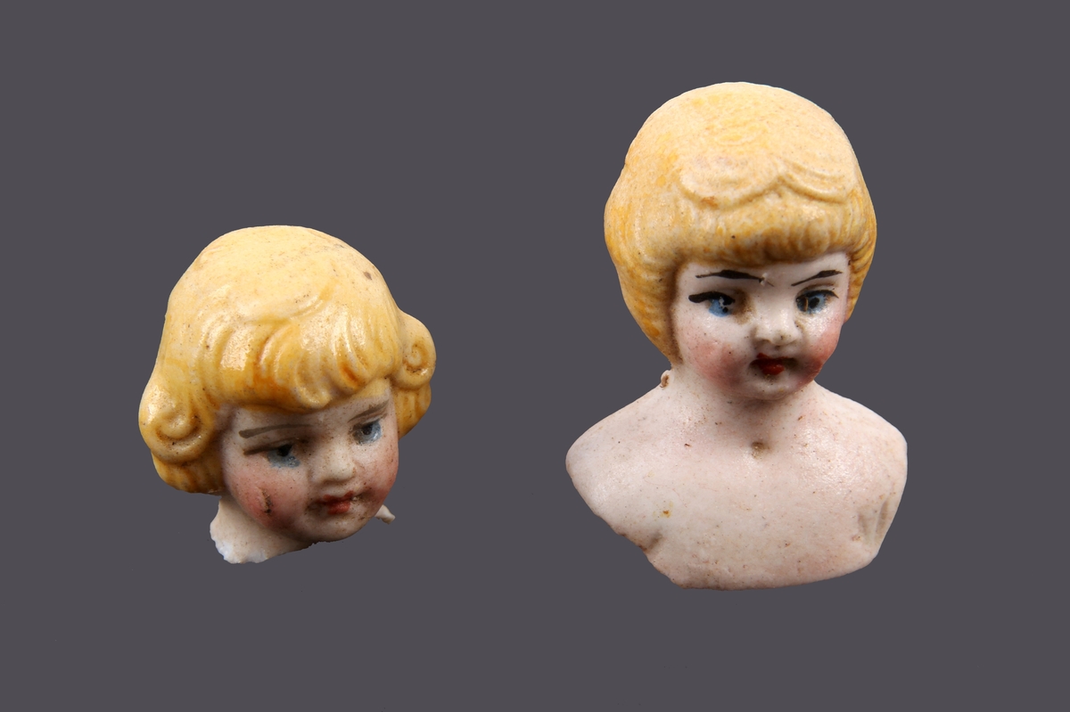 To små dukkehoder med håndmalte detaljer. Blondt hår og blå øyne